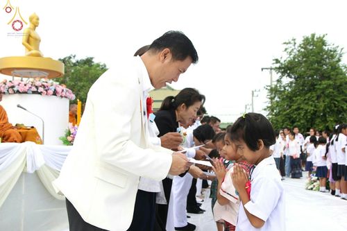 ผู้ใหญ่ใจดีมอบทุนการศึกษาให้เด็กนักเรียนที่พนมมือรับในงานพิธีตักบาตรพระสงฆ์