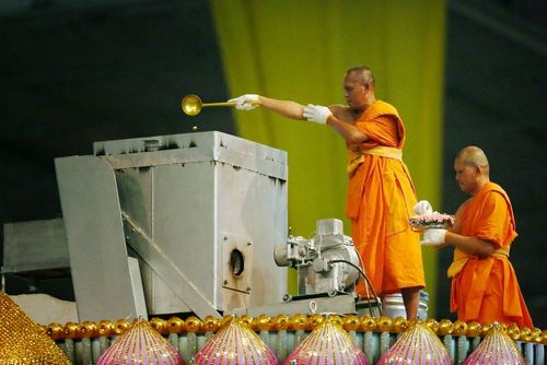 พระภิกษุสงฆ์กำลังประกอบพิธีเททองหล่อรูปหล่อทองคำพระมงคลเทพมุนีฯ