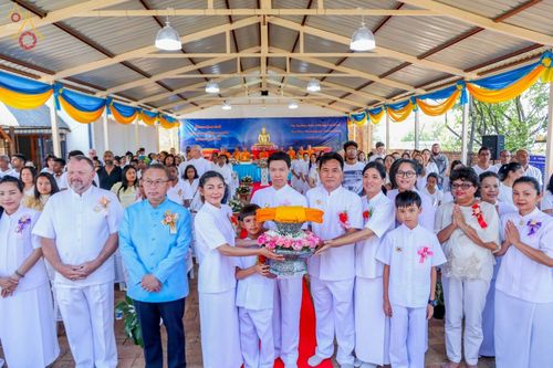 กลุ่มพุทธศาสนิกชนในชุดขาวร่วมพิธีทอดกฐินสามัคคีและถือพานผ้าไตรกฐินภายในอุโบสถวัดพระธรรมกายโจฮันเนสเบิร์ก