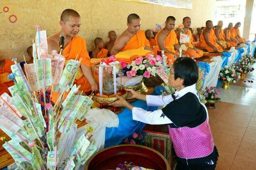พุทธศาสนิกชนหญิงกำลังประเคนพานพุ่มเงินกฐินแด่พระภิกษุสงฆ์ในพิธีทอดกฐินสามัคคีที่วัดทุ่งเจริญธรรม