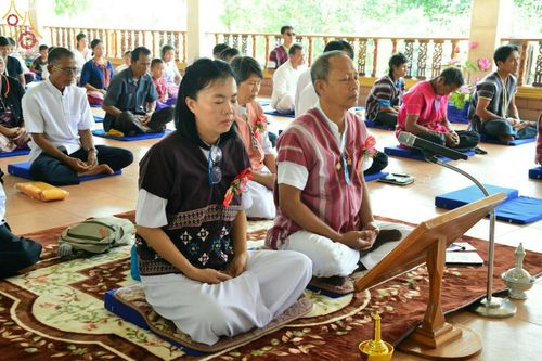 พุทธศาสนิกชนนั่งพนมมือประกอบพิธีทอดกฐินสามัคคีภายในศาลาวัดทุ่งเจริญธรรม