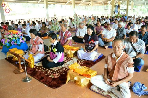 กลุ่มพุทธศาสนิกชนแต่งกายชุดพื้นเมืองนั่งบนอาสนะร่วมพิธีทอดกฐินสามัคคีภายในศาลาวัดทุ่งเจริญธรรม