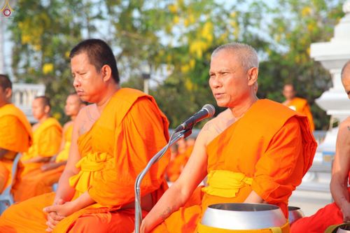 พระภิกษุสงฆ์กำลังประกอบพิธีทางศาสนาและกล่าวผ่านไมโครโฟนในงานทำบุญตักบาตรที่วัดดอนใหญ่