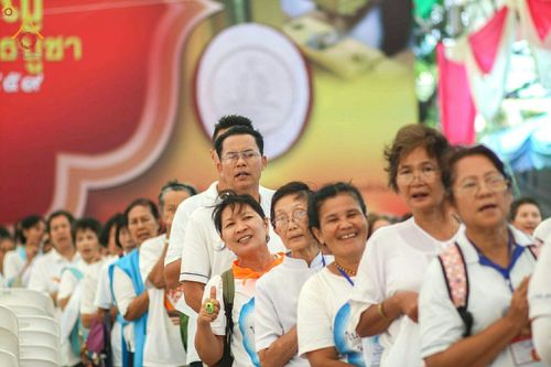 กลุ่มพุทธศาสนิกชนสวมชุดขาวเข้าแถวรอร่วมพิธีพิมพ์พระของขวัญรุ่นบรรลุธรรม
