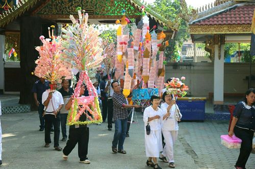 กลุ่มชาวบ้านถือต้นกฐินประดับธนบัตรเดินในขบวนแห่เข้าสู่วัดขี้เหล็ก จังหวัดลำพูน