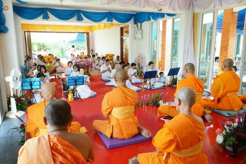 พระภิกษุสงฆ์และสาธุชนนั่งสวดมนต์ในพิธีทอดกฐินมหาสามัคคีภายในอาคารปฏิบัติธรรม
