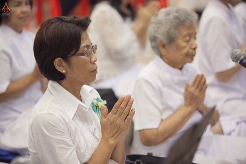 กลุ่มพุทธศาสนิกชนสวมชุดขาวพนมมือสวดมนต์ในพิธีทางศาสนา ณ ธุดงคสถานอ่างทอง