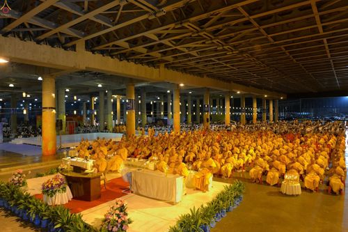 พระภิกษุสงฆ์จำนวนมากนั่งสมาธิและร่วมประกอบพิธีปิดแผ่นทองระฆังธรรมและสวดธัมมจักกัปปวัตนสูตรในอาคารขนาดใหญ่