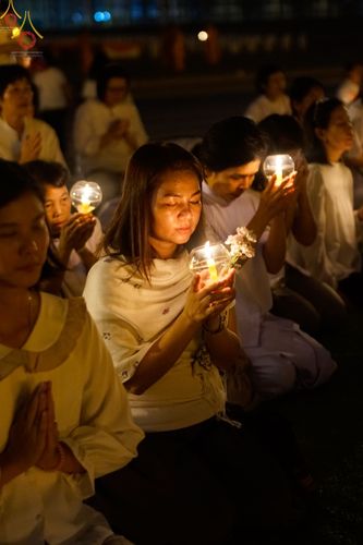 กลุ่มพุทธศาสนิกชนถือประทีปสว่างไสวในพิธีสวดมนต์และเวียนประทักษิณที่วัดพระธรรมกาย