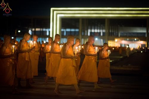 พระภิกษุสงฆ์จำนวนมากถือเทียนเดินเวียนประทักษิณในยามค่ำคืนที่วัดพระธรรมกาย