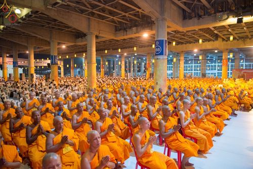 พระภิกษุสงฆ์จำนวนมากนั่งพนมมือสวดมนต์ภายในมหารัตนวิหารคด วัดพระธรรมกาย