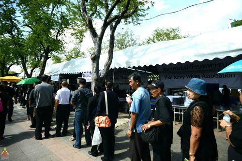 ประชาชนเข้าแถวรอรับอาหารและน้ำดื่มฟรีจากเต็นท์สมาคมแม่บ้านทหารบกเพื่อบริการผู้มาสักการะพระบรมศพฯ