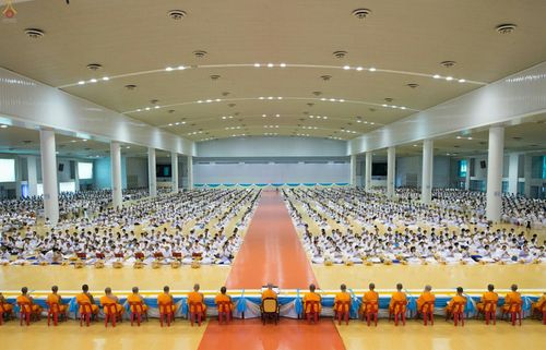คณะสงฆ์และพุทธศาสนิกชนจำนวนมากร่วมประกอบพิธีปุพพเปตพลีภายในอาคารขนาดใหญ่