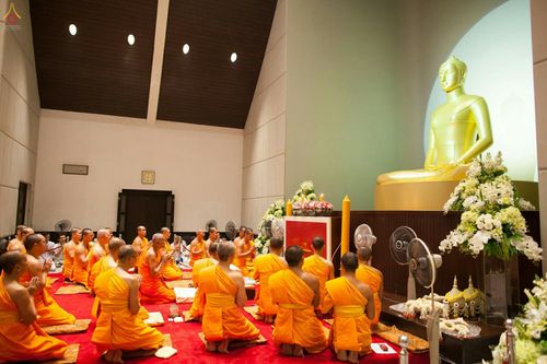 พระภิกษุสงฆ์นั่งสมาธิประกอบศาสนกิจเบื้องหน้าพระพุทธรูปในพิธีบรรพชาอุปสมบทหมู่