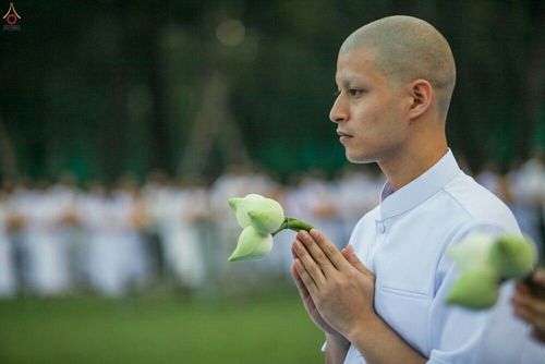 นาคธรรมทายาทชายโกนศีรษะสวมชุดขาวถือดอกบัวพนมมือในพิธีบรรพชาอุปสมบทหมู่