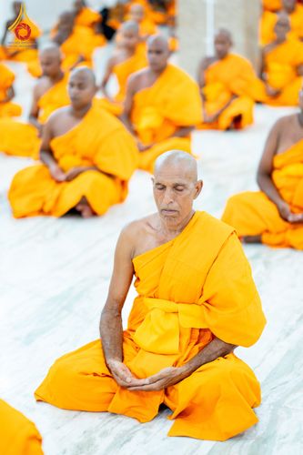พระภิกษุและสามเณรจำนวนมากกำลังนั่งสมาธิอย่างสงบในโครงการบรรพชาสามเณรที่ประเทศอินเดีย