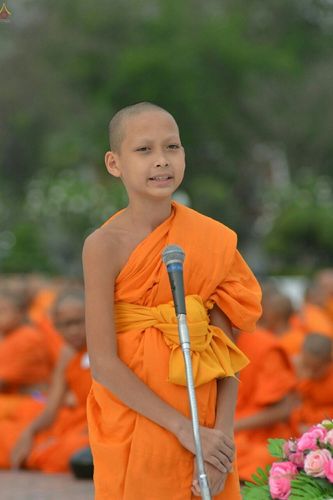 สามเณรน้อยยืนถือไมโครโฟนกล่าวธรรมะในงานตักบาตรสามเณรพุทธมณฑล