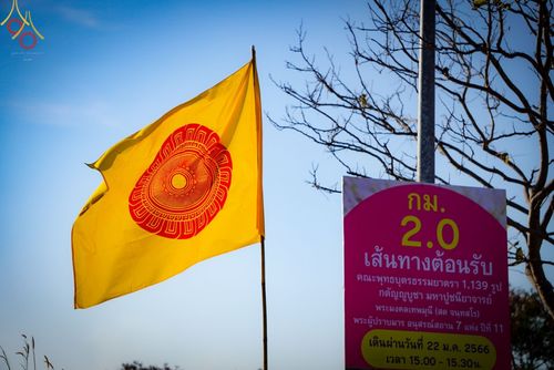 ธงสีเหลืองสัญลักษณ์ธรรมจักรและป้ายบอกเส้นทางต้อนรับคณะพระธรรมยาตรา