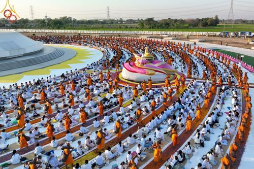 คณะพระธรรมยาตราและสาธุชนจำนวนมากนั่งล้อมรอบอนุสรณ์สถานบางปลาในพิธีต้อนรับพระธรรมยาตรา