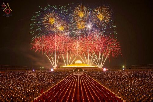 พุทธศาสนิกชนจำนวนมากถือประทีปในพิธีจุดประทีปบูชาพระมหาธรรมกายเจดีย์ท่ามกลางการแสดงพลุบนท้องฟ้า