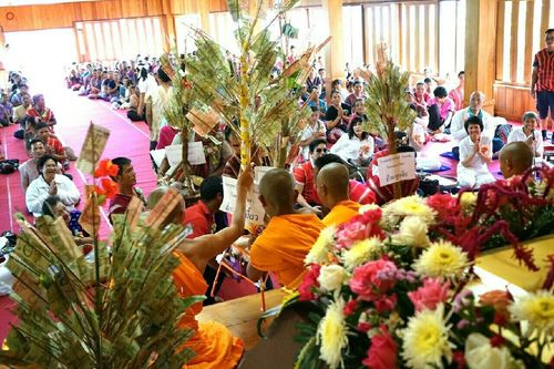 พระสงฆ์และพุทธศาสนิกชนร่วมพิธีทอดกฐินภายในศาลาวัดแม่ขิงที่มีต้นกฐินประดับด้วยธนบัตรและดอกไม้