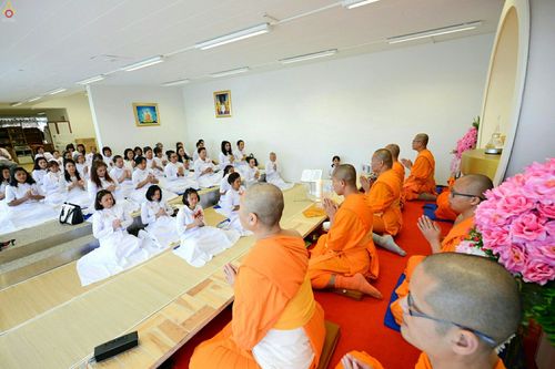 พระสงฆ์และพุทธศาสนิกชนชุดขาวร่วมพิธีทางศาสนาภายในวัดพุทธไอซ์แลนด์