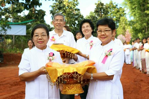 กลุ่มพุทธศาสนิกชนสวมชุดขาวถือพานพุ่มผ้ากฐินในพิธีทอดกฐินธรรมชัย