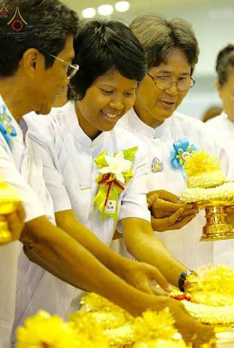 กลุ่มพุทธศาสนิกชนสวมชุดขาวถือพานดอกมะลิในกิจกรรมวันครูผู้ค้นพบวิชชาธรรมกาย