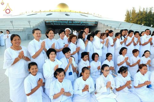 กลุ่มพุทธศาสนิกชนในชุดขาวพนมมือด้วยความศรัทธาหน้ามหารัตนวิหารคด