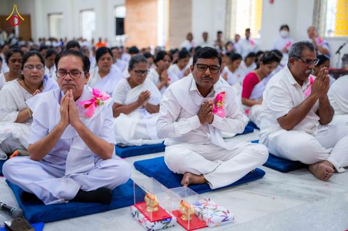 กลุ่มอุบาสกและอุบาสิกาสวมชุดขาวนั่งพนมมือปฏิบัติธรรมในพิธีปิดโครงการอบรม